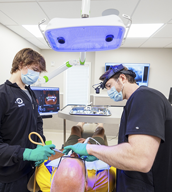 Oral surgeon and assistant performing a procedure on a patient