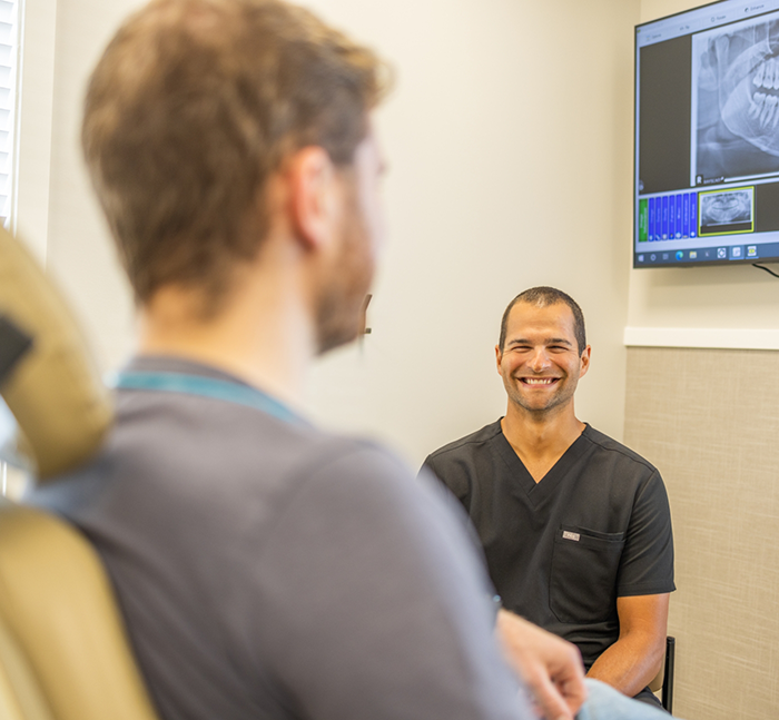 Oral surgeon smiling at a patient during a consultation for dental implants in Lancaster