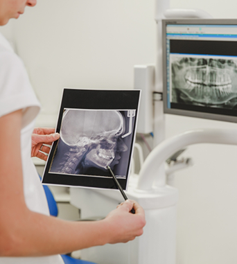 Dentist looking at an x ray of teeth