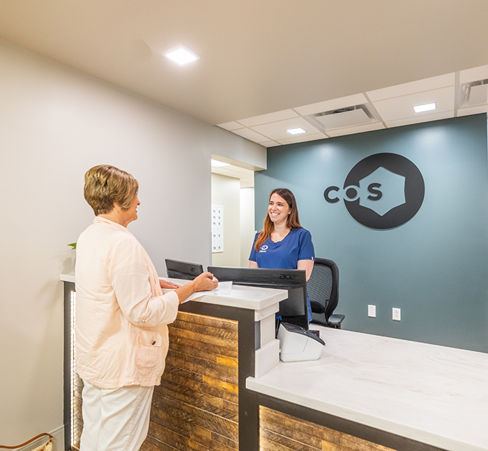 Woman checking in at front desk of oral surgery office in Lancaster