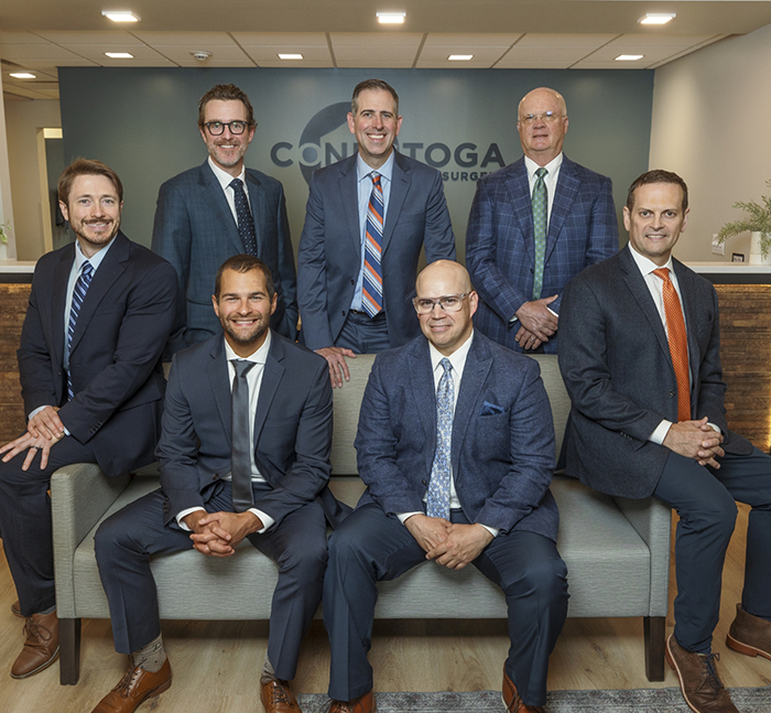 Seven Lancaster oral surgeons in suits in reception area of Conestoga Oral Surgery