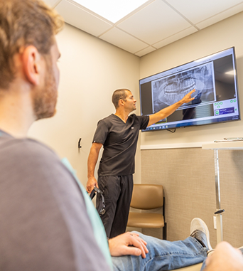 Oral surgeon showing a patient an x ray of their teeth