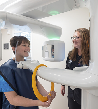 Patient receiving a cone beam C T scan of her jaws