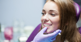 Oral surgeon looking at a smiling patients teeth