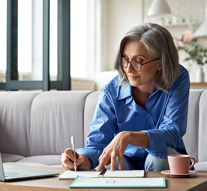 Woman writing in a notebook at home