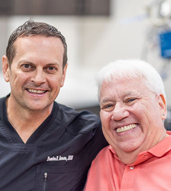 Oral surgeon smiling with an older male patient