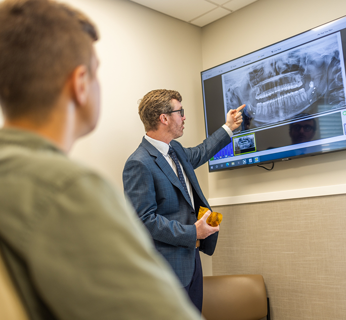 Oral surgeon showing a patient an x ray of their teeth