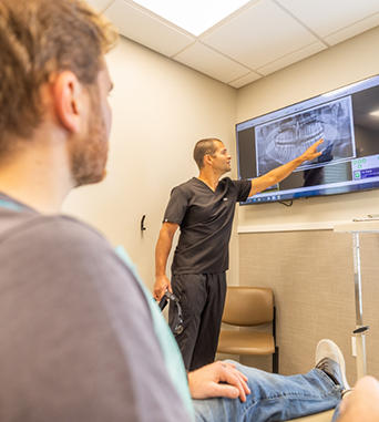 Oral surgeon showing a patient X rays of their teeth